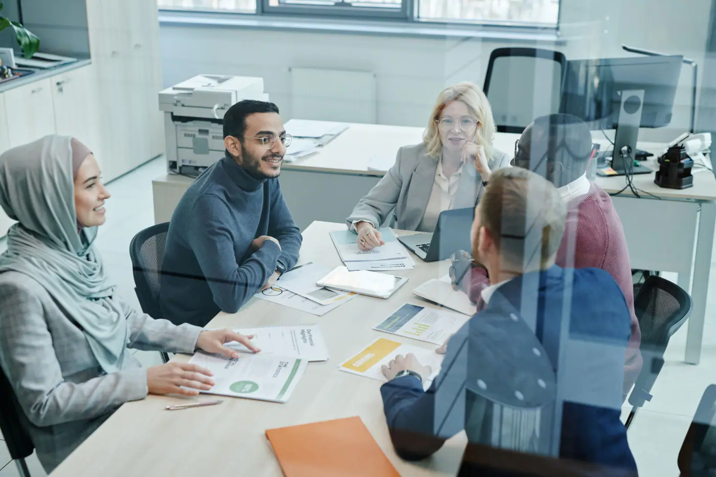 A diverse team discussing plans around a meeting table